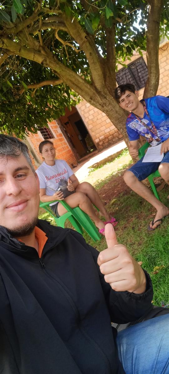 Entrega de documentación a una familia bajo un árbol