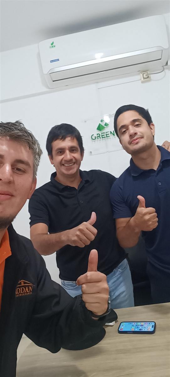Asesor y cliente firmando la reserva de un lote en el lugar